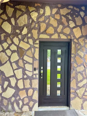 a front view of a house with a tree