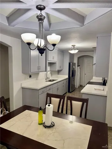 a kitchen with a table chairs and a chandelier