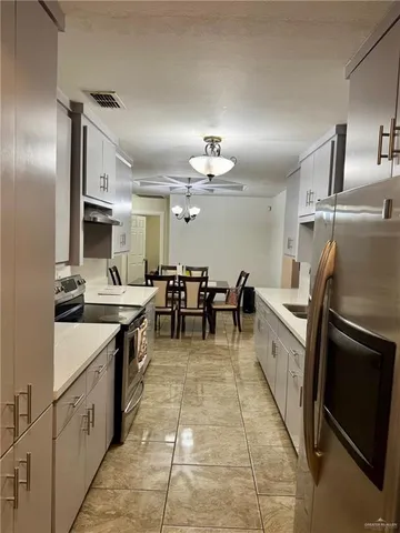 a large kitchen with cabinets and stainless steel appliances