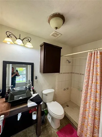 a bathroom with a toilet a sink and mirror