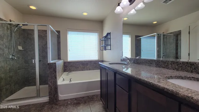 a bathroom with a granite countertop sink mirror and shower