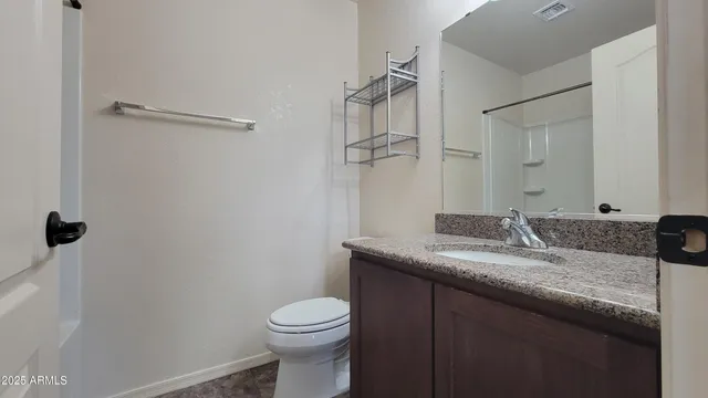 a bathroom with a granite countertop sink toilet and mirror