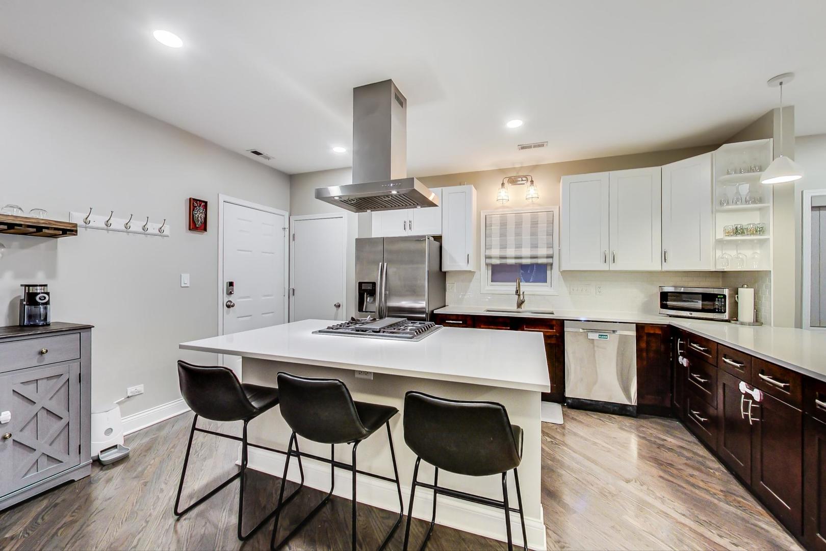1532 West Fry Street, Unit 1 Chicago, IL 60642 - Photo 10 of 34 a kitchen with kitchen island a stove a table and chairs in it