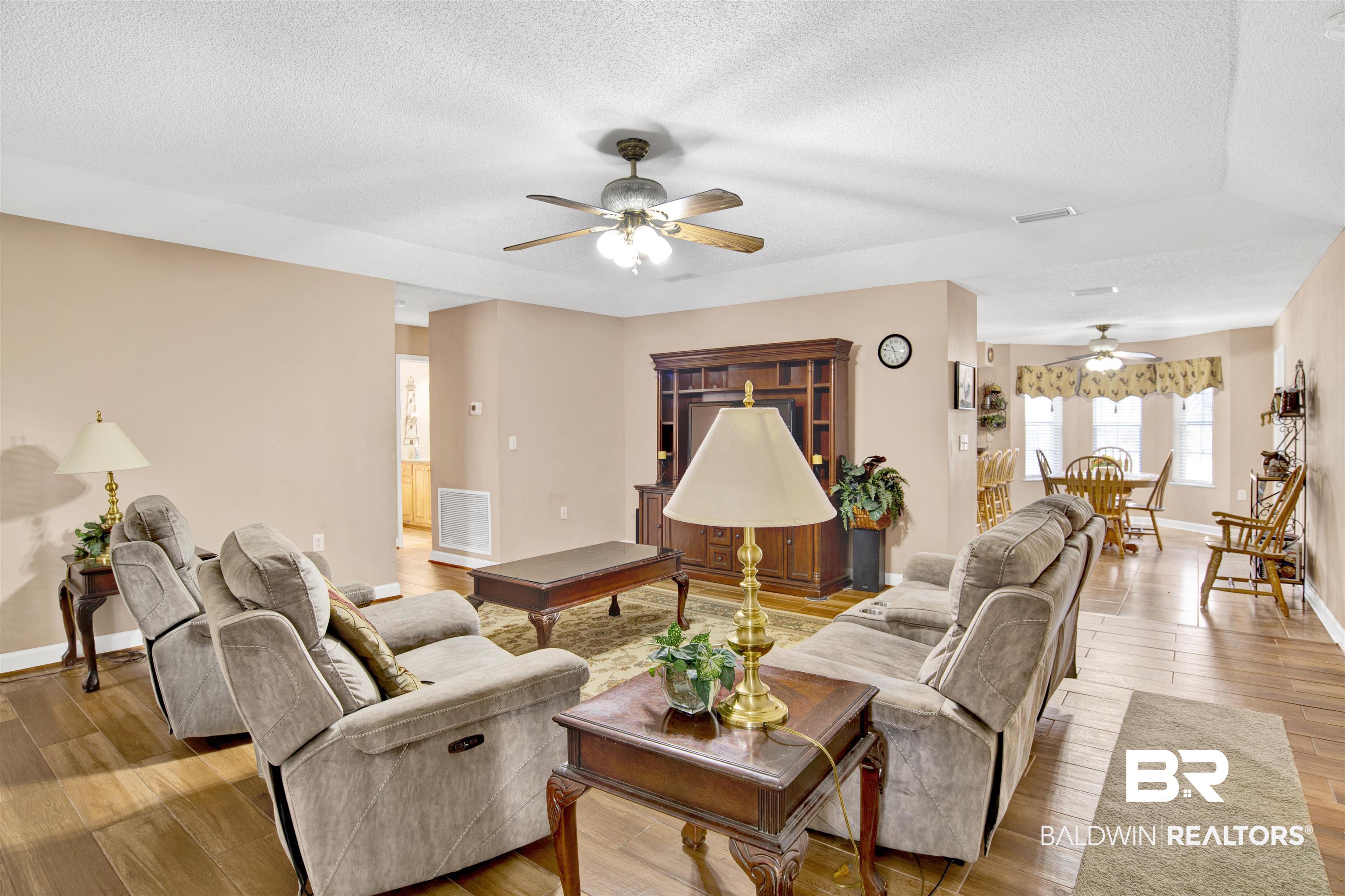 36434 Alexandria Trail Stapleton, AL 36578 - Photo 3 of 27 Living room featuring ceiling fan, light wood-style flooring, and a textured ceiling