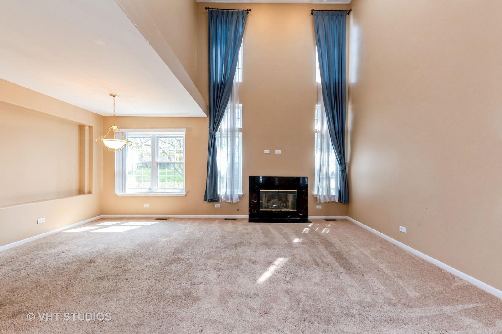 253 Hawk Court Schaumburg, IL 60193 - Photo 3 of 15 a view of an empty room with a fireplace and a window