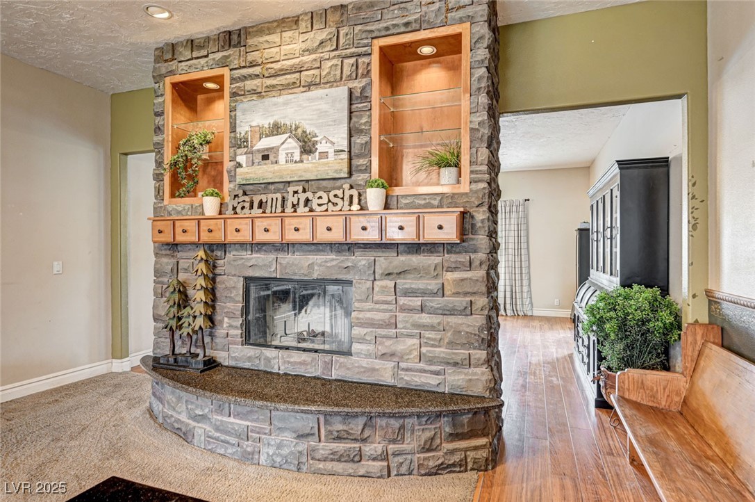1140 Mahoney Avenue Logandale, NV 89021 - Photo 16 of 51 Living room with a textured ceiling, a fireplace, and hardwood / wood-style floors