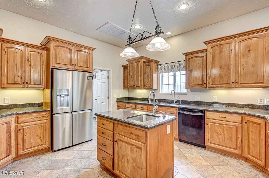 1140 Mahoney Avenue Logandale, NV 89021 - Photo 20 of 51 Kitchen featuring stainless steel refrigerator with ice dispenser, an island with sink, dark stone countertops, hanging light fixtures, and recessed lighting