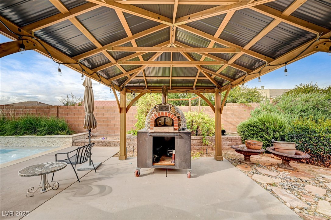 1140 Mahoney Avenue Logandale, NV 89021 - Photo 39 of 51 Fenced backyard featuring a patio, exterior fireplace, an outdoor pool, and a gazebo