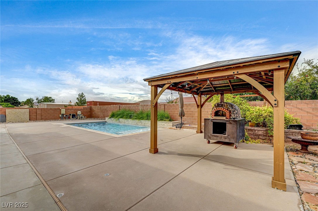 1140 Mahoney Avenue Logandale, NV 89021 - Photo 8 of 51 View of swimming pool with a fenced backyard, a patio, a fireplace, and a gazebo