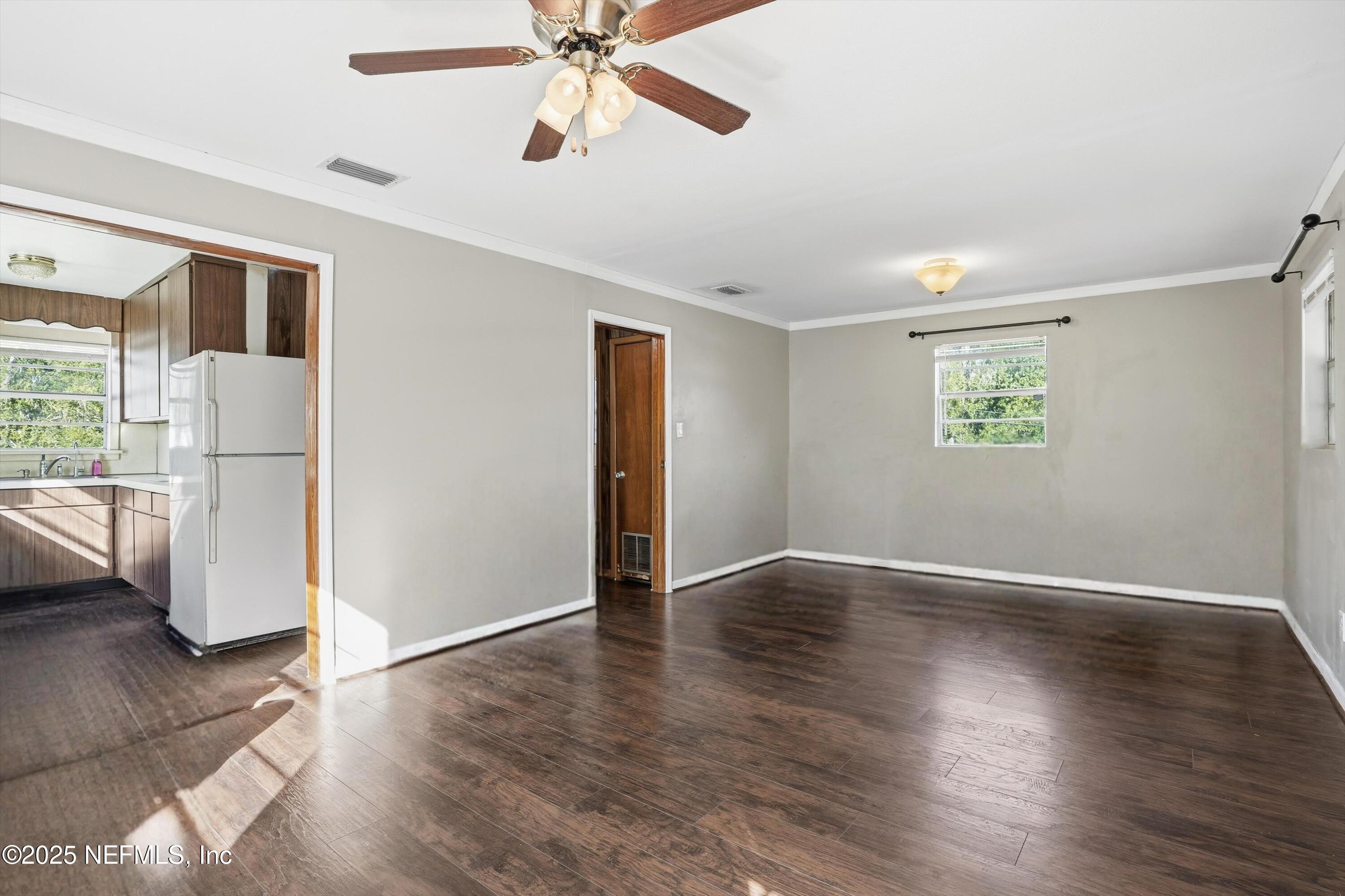 11558 Raft Road Jacksonville, FL 32218 - Photo 16 of 32 a view of an empty room with a window and wooden floor