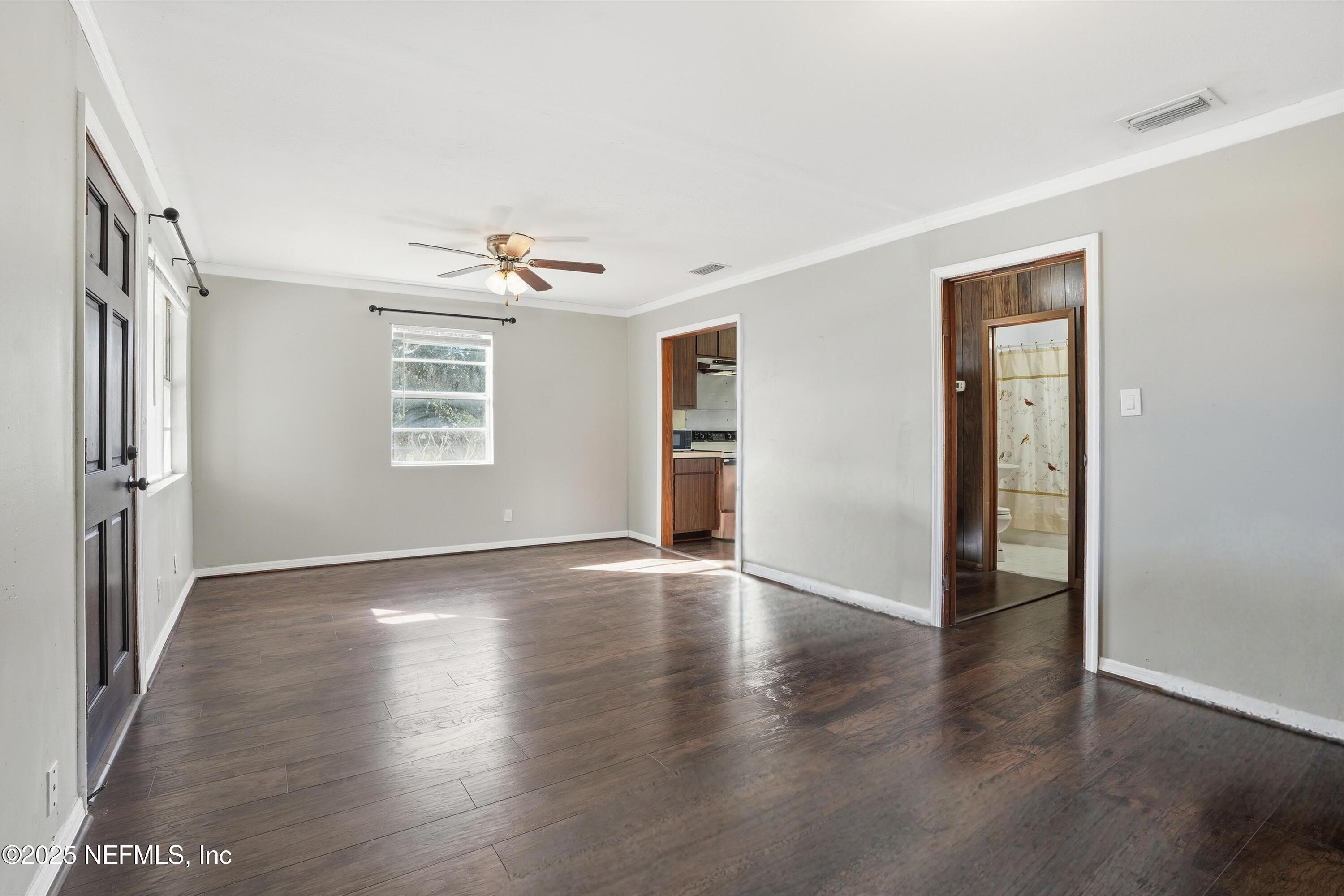 11558 Raft Road Jacksonville, FL 32218 - Photo 17 of 32 an empty room with wooden floor chandelier and windows