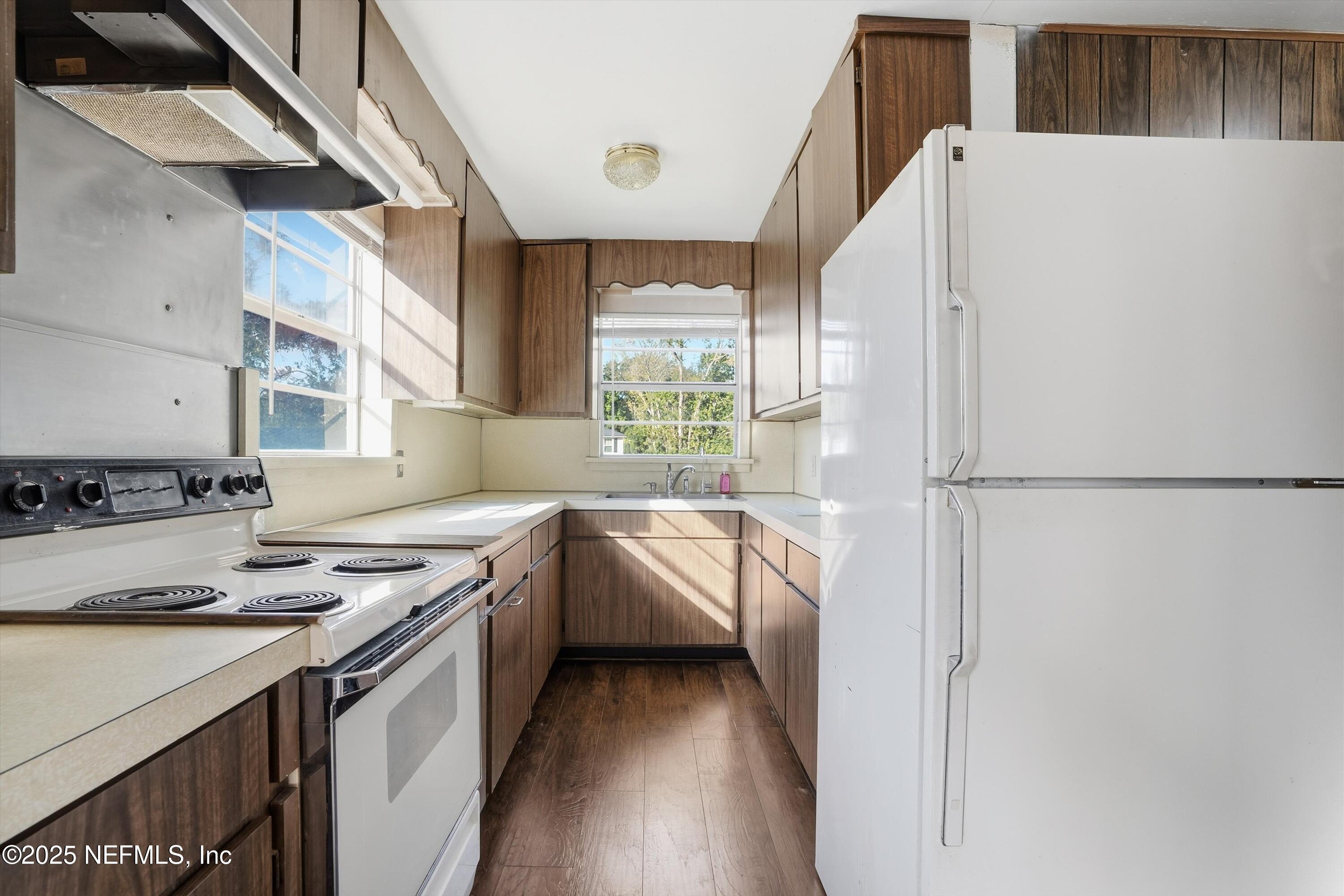 11558 Raft Road Jacksonville, FL 32218 - Photo 18 of 32 a kitchen with white cabinets and white appliances