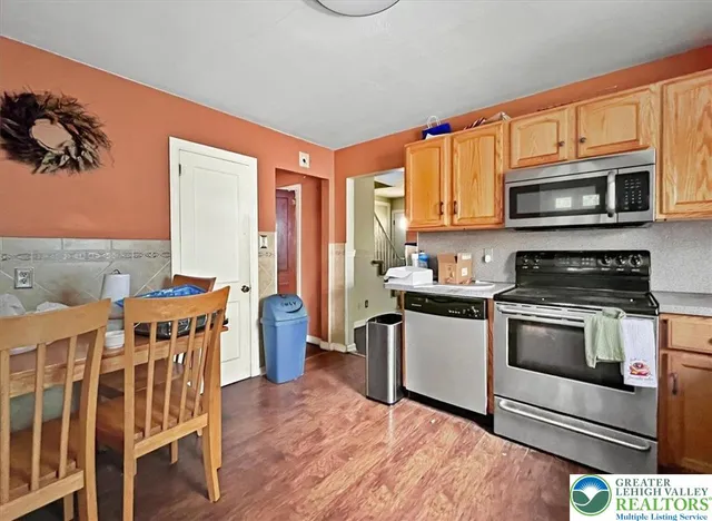 a kitchen with stainless steel appliances kitchen island granite countertop a stove a sink and a microwave