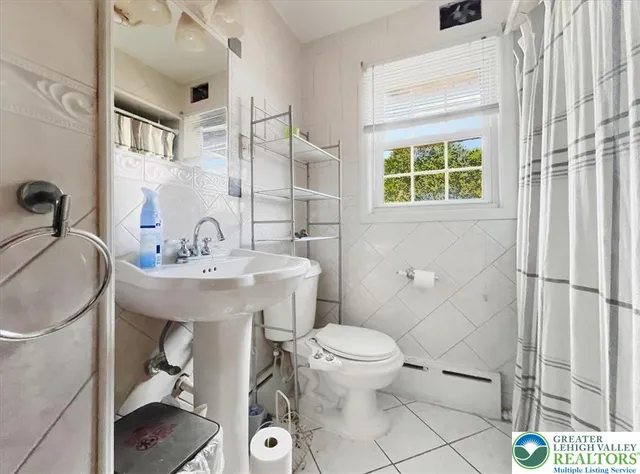 a bathroom with a sink toilet and a mirror