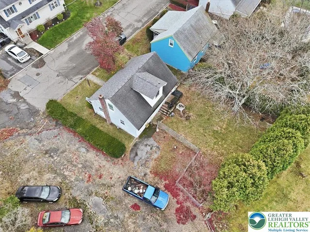 an aerial view of a house with a garden and lake view