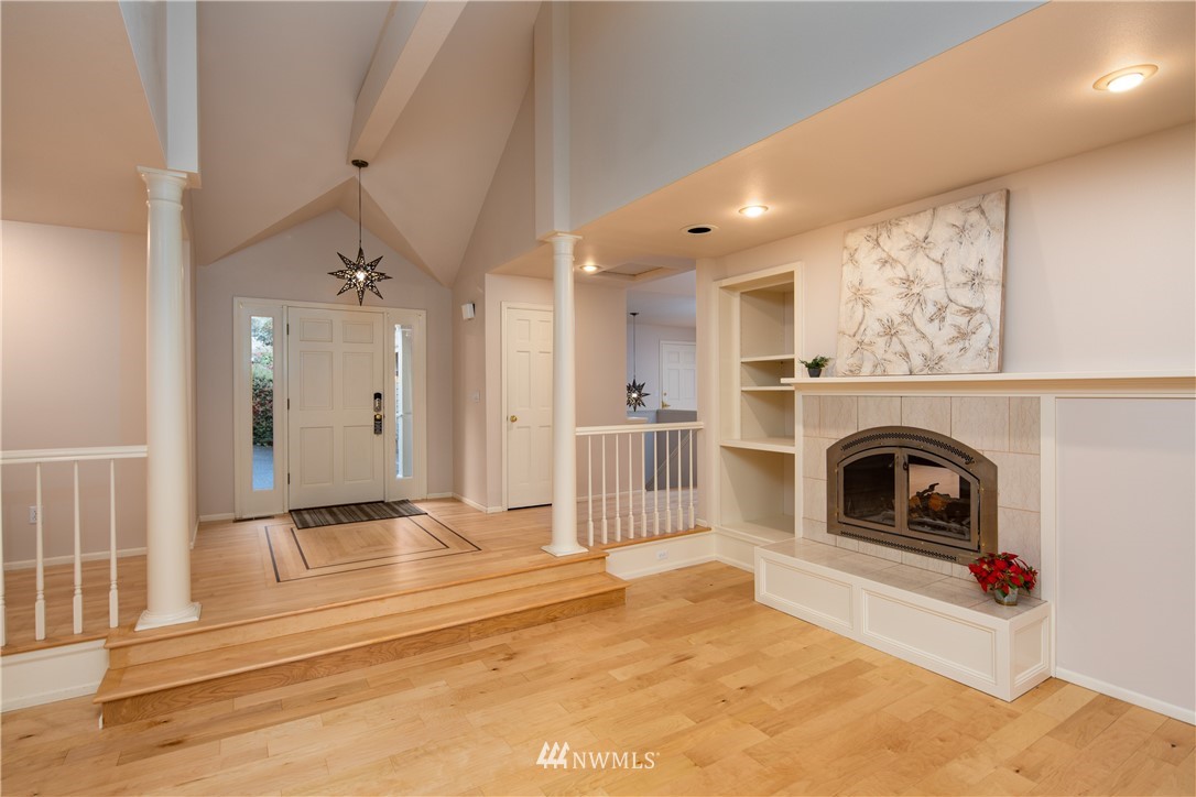 208 Sea Pines Road Bellingham, WA 98229 - Photo 13 of 34 a view of a livingroom with a fireplace a ceiling fan and windows