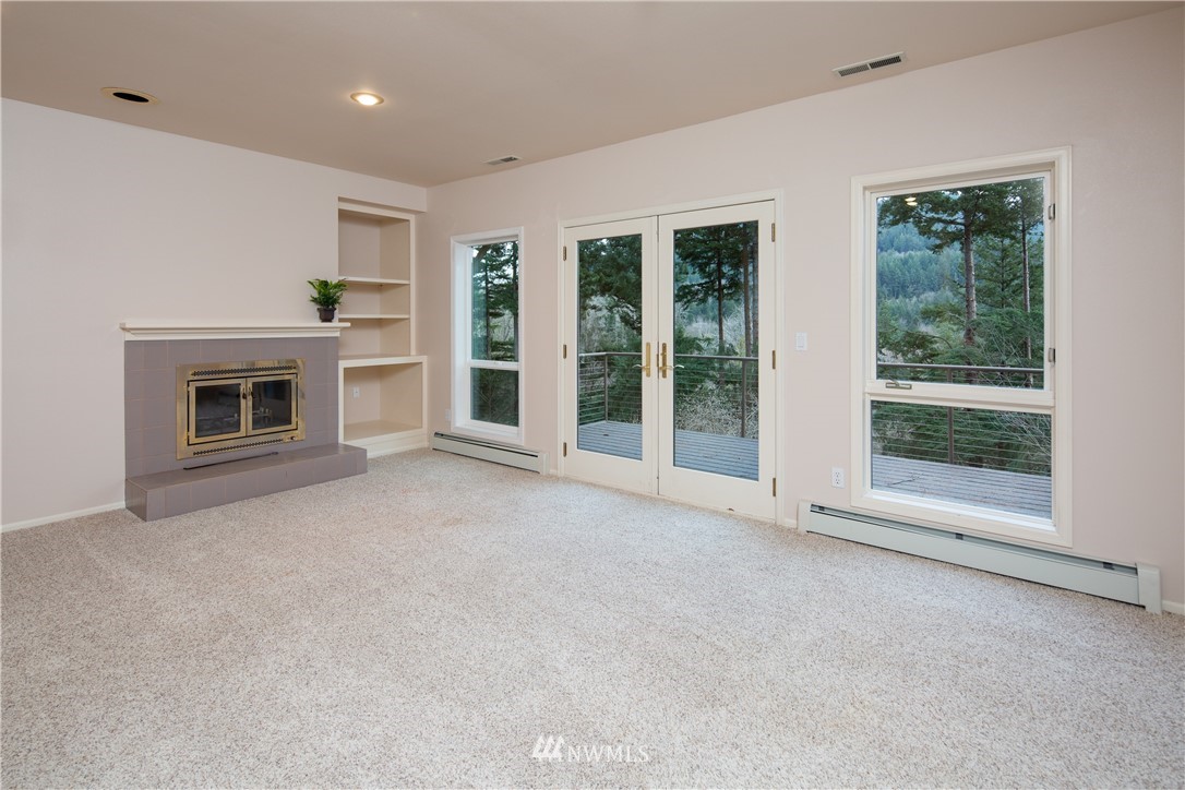 208 Sea Pines Road Bellingham, WA 98229 - Photo 29 of 34 a view of empty room with floor to ceiling window and fireplace