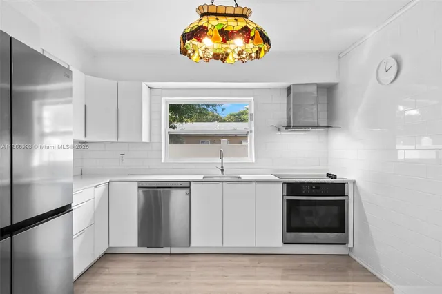 a kitchen with stainless steel appliances white cabinets and a sink