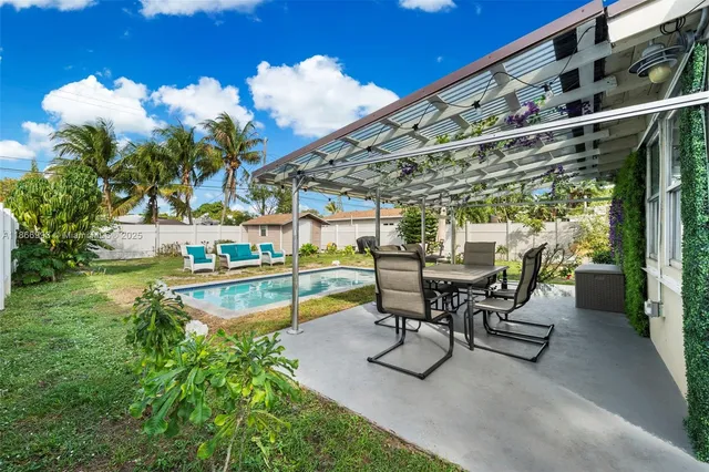 a view of swimming pool with outdoor seating and a patio