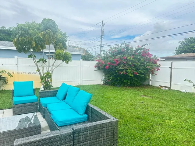 a view of backyard with seating area and trees