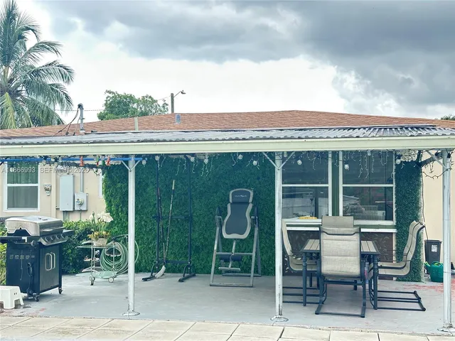 a view of a patio with table and chairs with wooden floor and fence