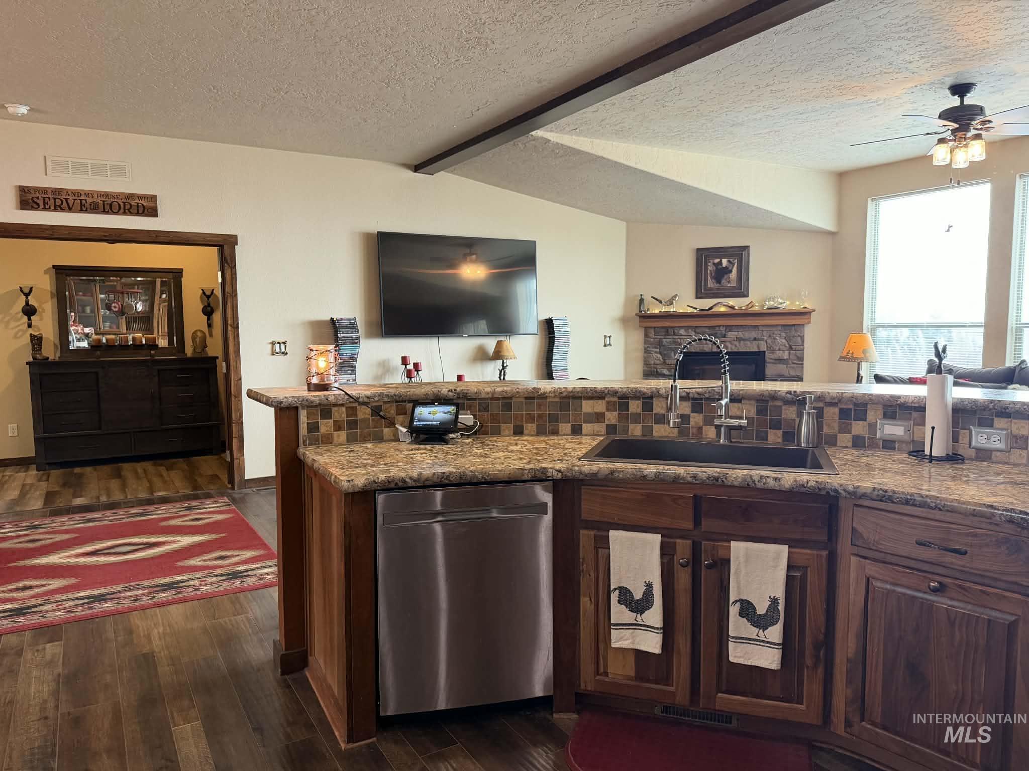 19378 Homestead Loop Lewiston, ID 83501 - Photo 42 of 42 Kitchen featuring dishwasher, a textured ceiling, open floor plan, dark wood-style flooring, and dark brown cabinets