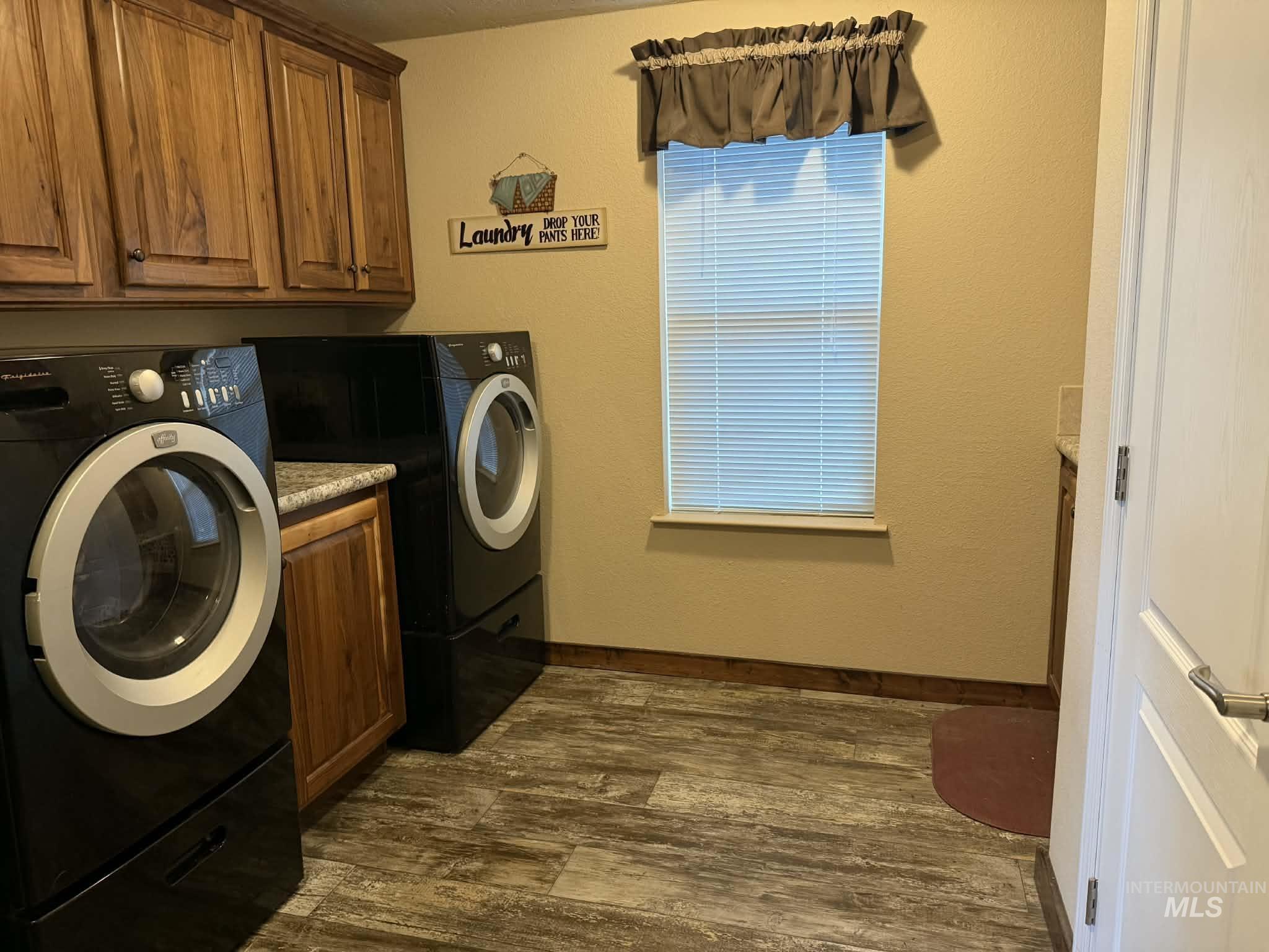19378 Homestead Loop Lewiston, ID 83501 - Photo 36 of 42 Washroom featuring dark wood finished floors, a textured wall, cabinet space, and washing machine and dryer