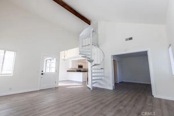 a view of a livingroom with wooden floor and staircase