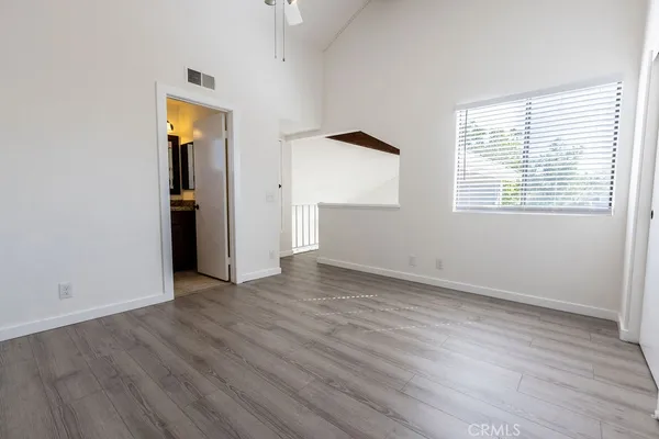 an empty room with wooden floor and windows