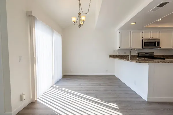 a kitchen with kitchen island granite countertop a sink cabinets and stainless steel appliances
