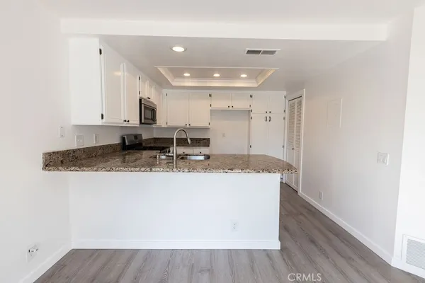 a view of kitchen with granite countertop cabinets and sink