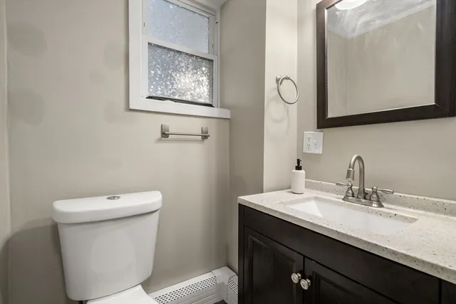 a bathroom with a toilet sink and mirror