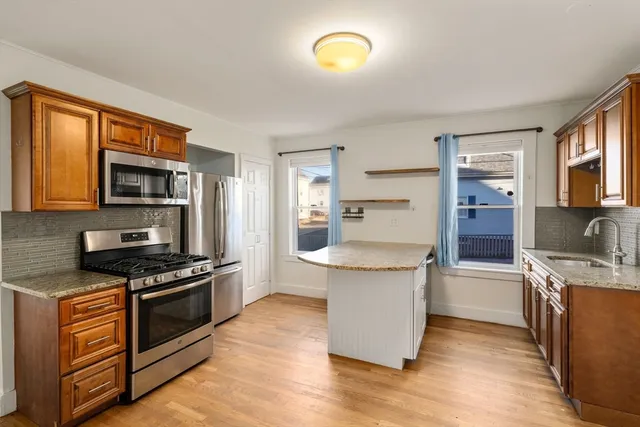 a kitchen with stainless steel appliances granite countertop a stove and a refrigerator