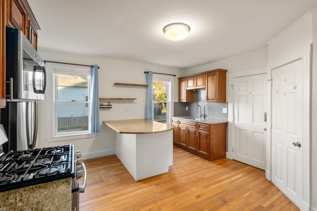 55 Butler Street Salem, MA 01970 - Photo 23 of 31 a kitchen with a sink stove and cabinets