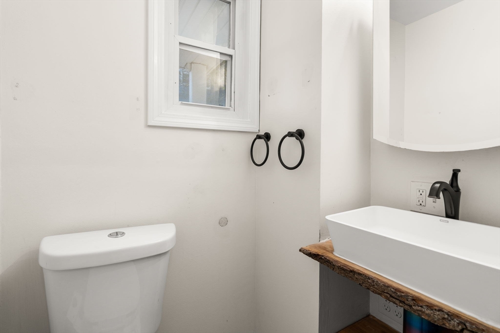 55 Butler Street Salem, MA 01970 - Photo 30 of 31 a bathroom with a sink a toilet and a mirror