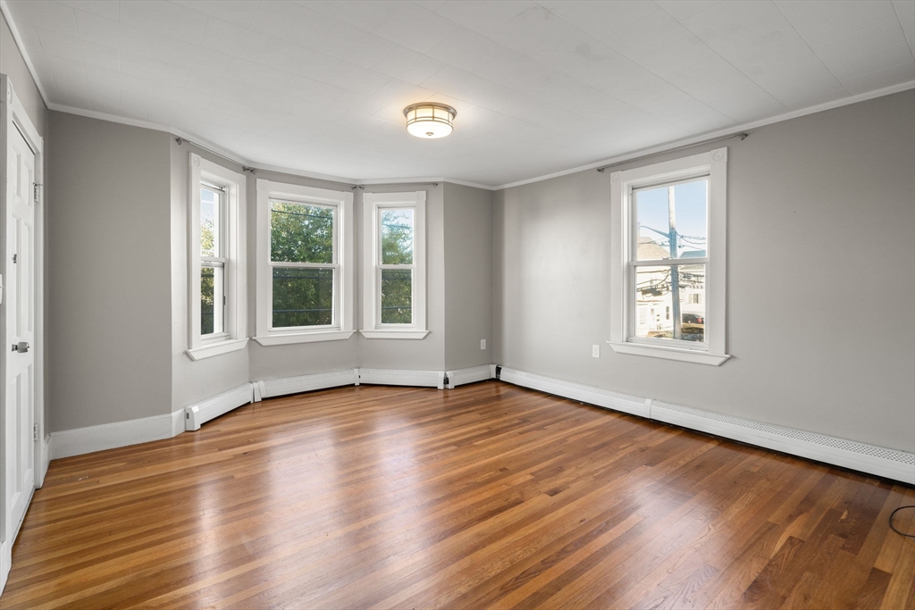 55 Butler Street Salem, MA 01970 - Photo 4 of 31 a view of empty room with wooden floor and fan