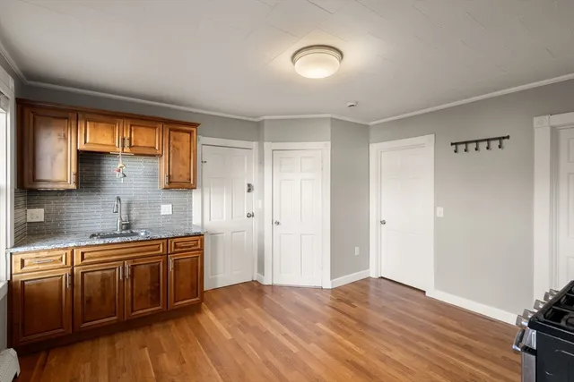 a kitchen with stainless steel appliances granite countertop a sink cabinets and wooden floor