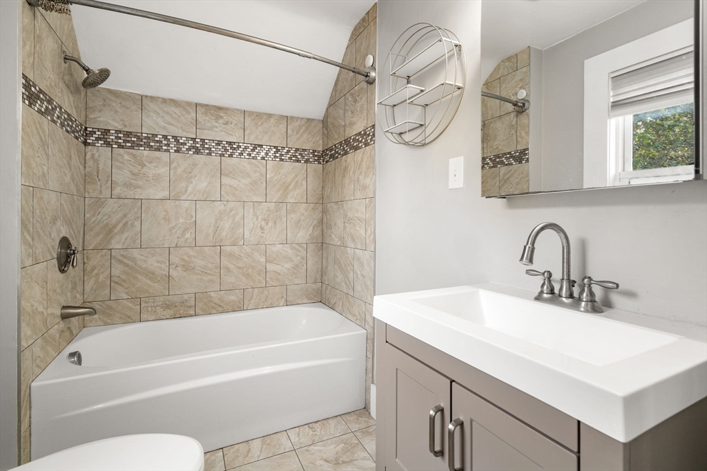 55 Butler Street Salem, MA 01970 - Photo 9 of 31 a bathroom with a sink a mirror and a bathtub