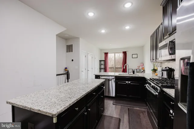 a kitchen with granite countertop stove sink and cabinets