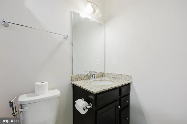 a bathroom with a sink vanity and a toilet