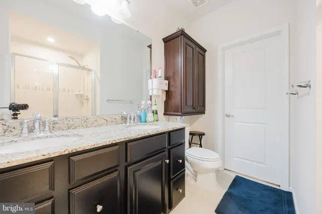 a bathroom with a granite countertop sink mirror and toilet