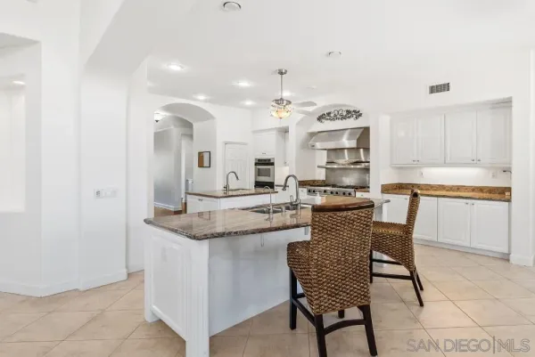 a kitchen with granite countertop white cabinets and white appliances