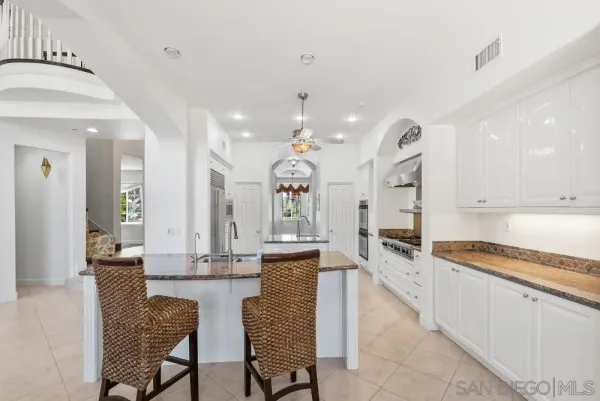 a kitchen with granite countertop white cabinets white appliances with a sink and dishwasher