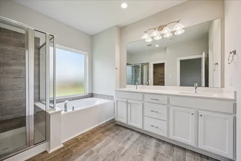 a spacious bathroom with a tub sink and mirror