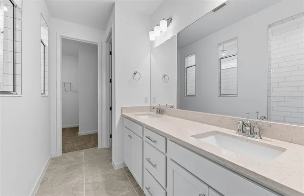 a bathroom with a double vanity sink mirror and next to a white cabinet