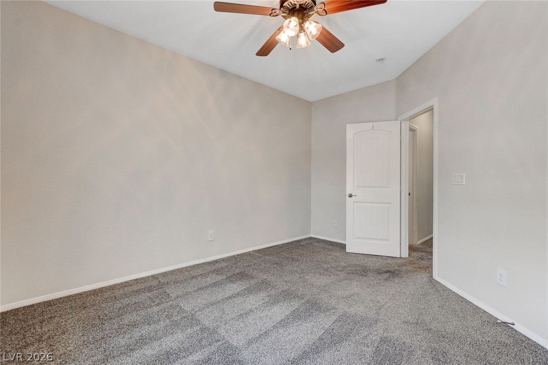 191 Verde Ridge Court Henderson, NV 89012 - Photo 27 of 36 Carpeted empty room featuring a ceiling fan, baseboards, and vaulted ceiling
