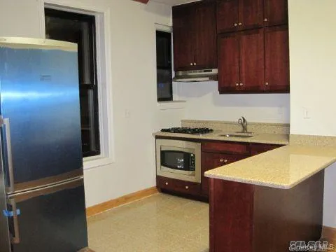 a kitchen with stainless steel appliances granite countertop a stove a microwave and a refrigerator