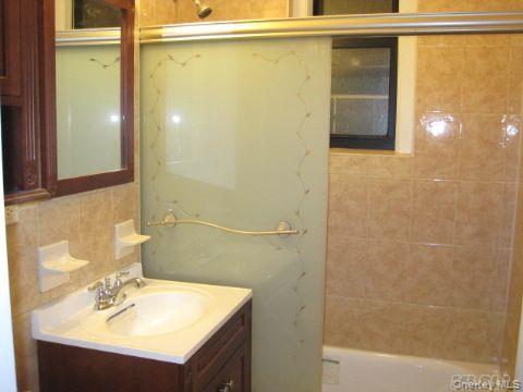 43-33 48th Street, Unit 1A Queens, NY 11104 - Photo 8 of 14 a bathroom with a sink and a mirror