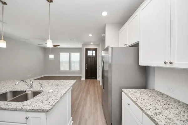a kitchen with kitchen island granite countertop a sink cabinets and stainless steel appliances
