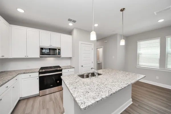a kitchen with granite countertop a stove and a sink